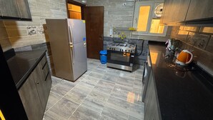Uma cozinha moderna com frigorífico, forno e fogão a gás.