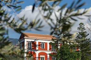 Ein zweistöckiges Gebäude mit roter und weißer Fassade, zahlreichen Fenstern und einem geneigten Dach.