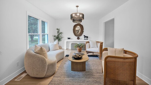 A modern living room with a large window, a chandelier, a fireplace, and a dining area. - Casa Azul an interior designed home in Stonehaven.Security System,Fiber Internet (Charlotte)