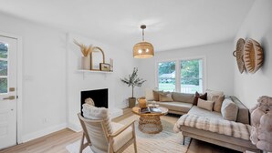 A modern living room with a fireplace, a sofa, a chair, and a coffee table. - Casa Azul an interior designed home in Stonehaven.Security System,Fiber Internet (Charlotte)