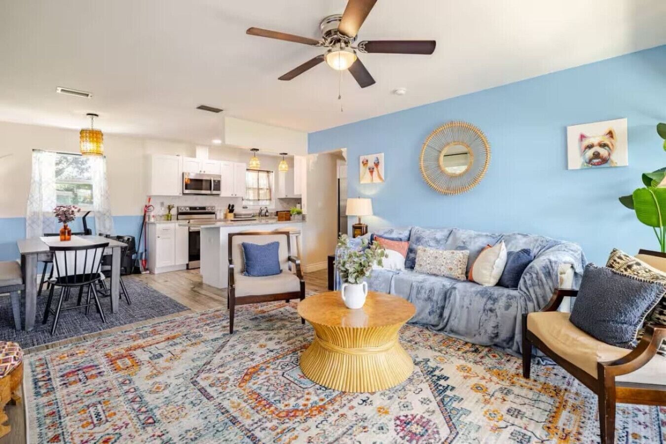 A spacious living area with a sofa, coffee table, and a dining table with chairs.