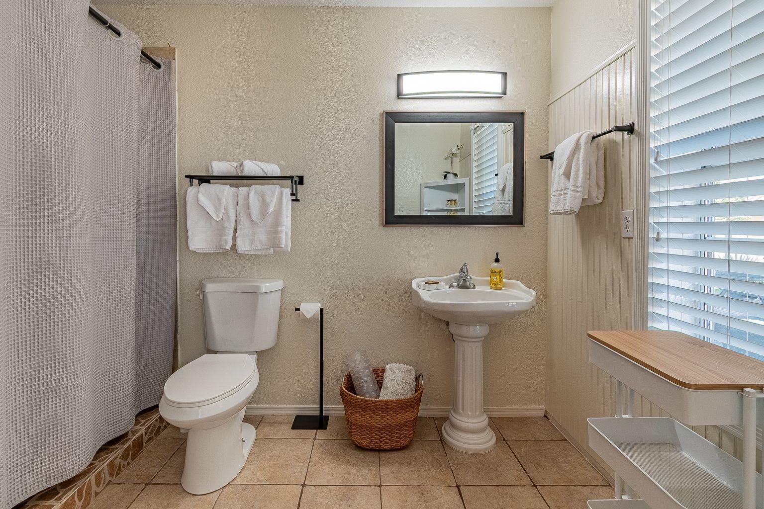 Un bagno con il water, un lavandino e una tenda per la doccia.