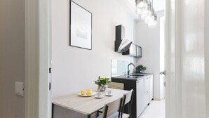 Una cocina moderna con comedor, que incluye una mesa de tonos claros, sillas y una pequeña planta en maceta.