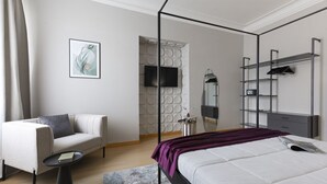 Un dormitorio moderno con una cama con dosel, un sofá, una mesa de centro, un televisor y estanterías empotradas.