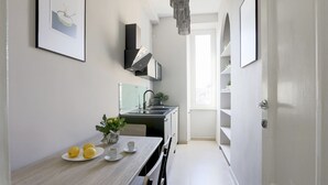Una cocina moderna con una mesa de comedor, sillas, un lavamanos y un refrigerador.