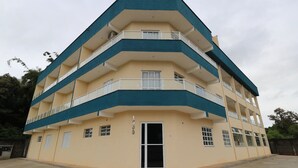 Un immeuble à plusieurs étages, doté de balcons et d’une façade plane.