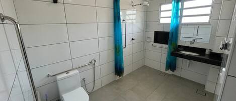 Une salle de bain moderne équipée de toilettes, d’une douche et d’un lavabo.