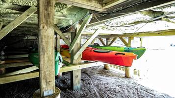 Une structure en bois, avec des kayaks suspendus en dessous.