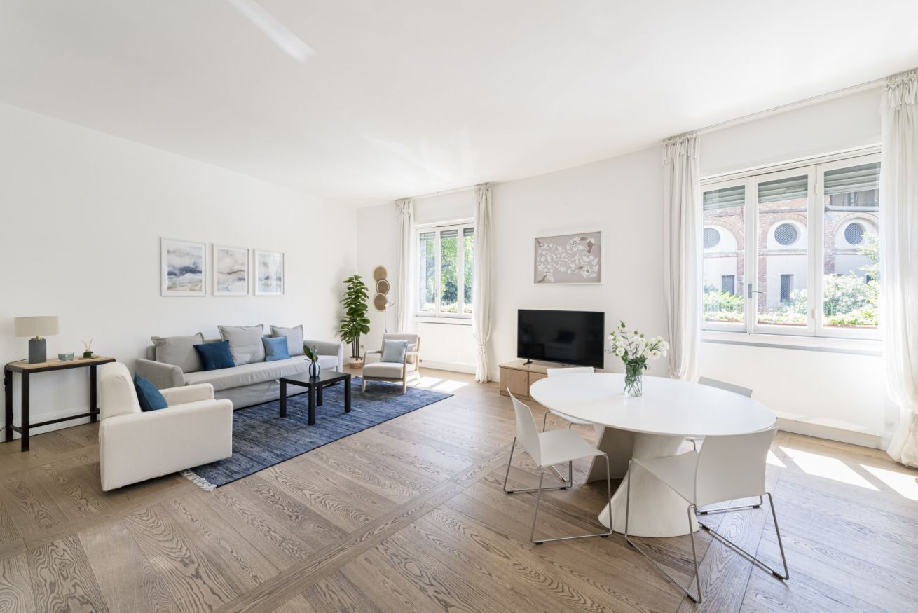 Ett modernt vardagsrum med en soffa, ett soffbord, en tv och en matplats.