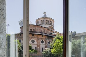 A historic building with a central dome and arched windows, surrounded by greenery and a metal fence. - Easylife - Urban charm and comfort in Porta Romana (Milano)