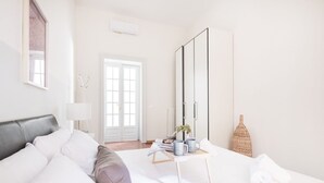 Ein modernes Schlafzimmer mit Bett, Nachttisch und Kleiderschrank.