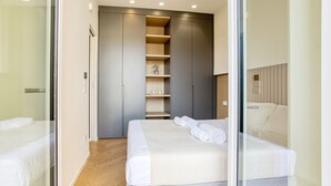 A modern bedroom with a large bed, a built-in wardrobe, and a glass partition. - Easylife - Style and balcony near the Duomo (Milano)