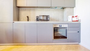 A modern kitchen with grey cabinets, a built-in microwave, and an oven. - Easylife - Style and balcony near the Duomo (Milano)
