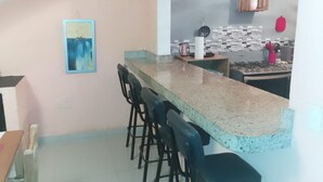 A kitchen with a granite countertop, bar stools, a microwave, and a hanging cabinet. - Rustic private 2BR/1.5ba house with yard in Bucerías Centro near Puerto Vallarta (Bucerías)