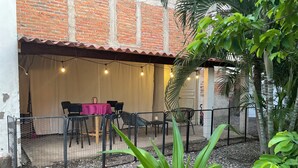 An outdoor patio area with a table set for dining, surrounded by chairs, and a fence enclosing the space. - Rustic private 2BR/1.5ba house with yard in Bucerías Centro near Puerto Vallarta (Bucerías)