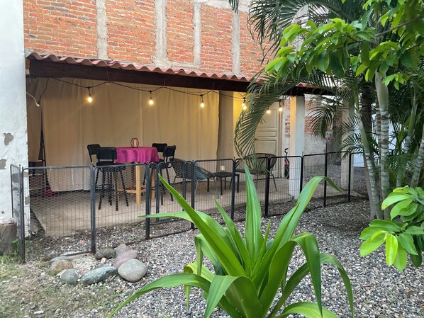 An outdoor patio area with a table set for dining, surrounded by chairs, and a fence enclosing the space. - Rustic private 2BR/1.5ba house with yard in Bucerías Centro near Puerto Vallarta (Bucerías)