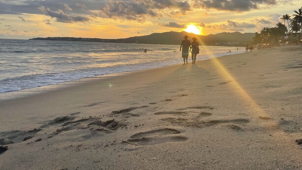 A beach scene with footprints leading to the water, palm trees, and a sunset in the background. - Rustic private 2BR/1.5ba house with yard in Bucerías Centro near Puerto Vallarta (Bucerías)
