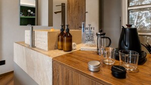 A modern kitchen with a wooden countertop, a coffee maker, a kettle, and a QR code for WiFi access. - BoH Collection (Medellín)