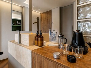 A modern kitchen with a wooden countertop, a coffee maker, a kettle, and a QR code for WiFi access. - BoH Collection (Medellín)