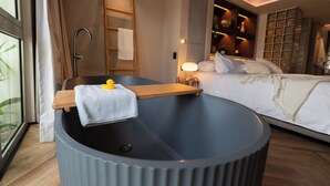 A modern bathroom with a bathtub, wooden shelf, and a towel. - BoH Collection (Medellín)