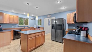 Una cocina moderna con armarios de madera, un refrigerador de acero inoxidable y una isla central.