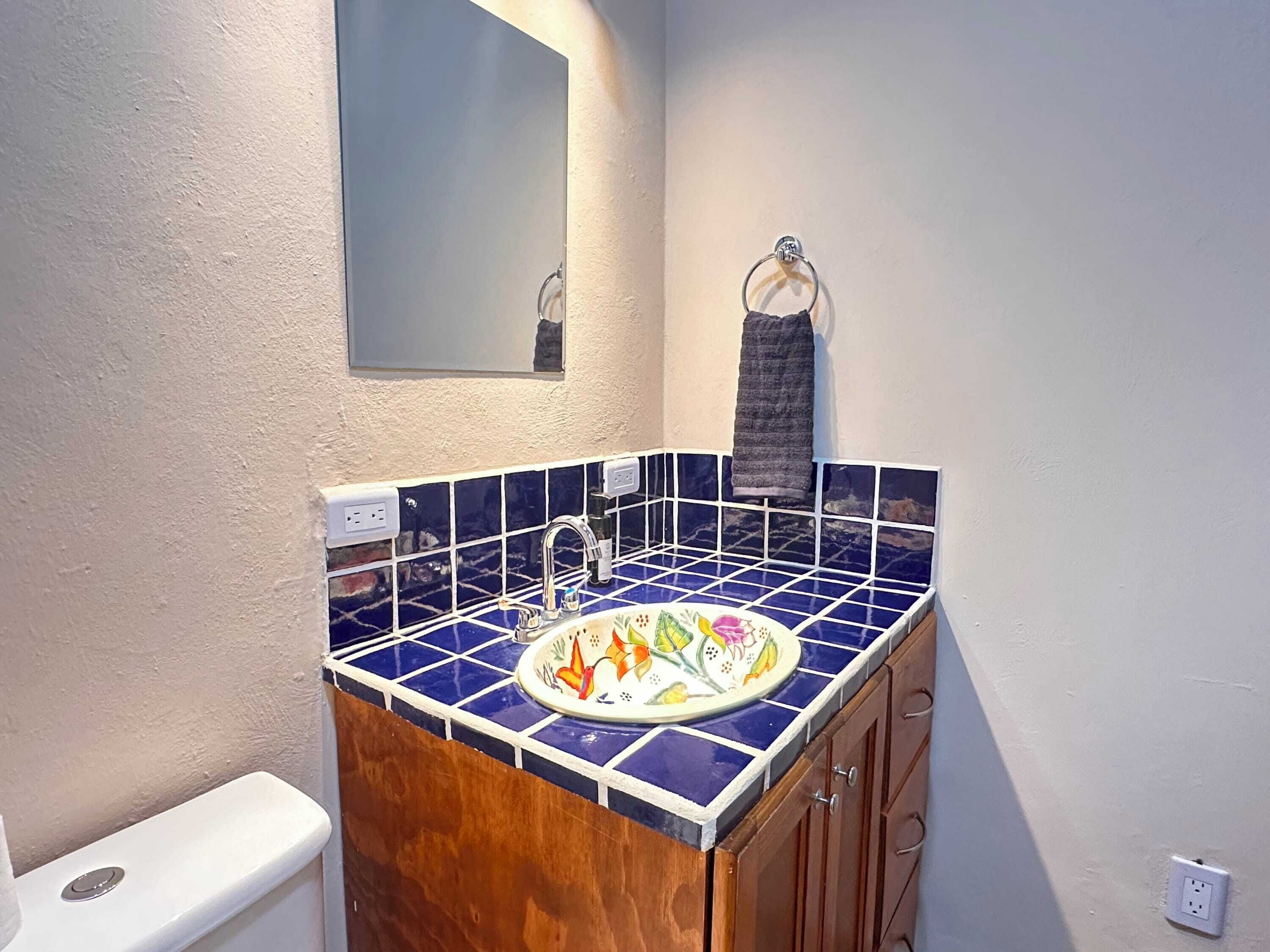 A bathroom with a sink, mirror, and towel rack.
