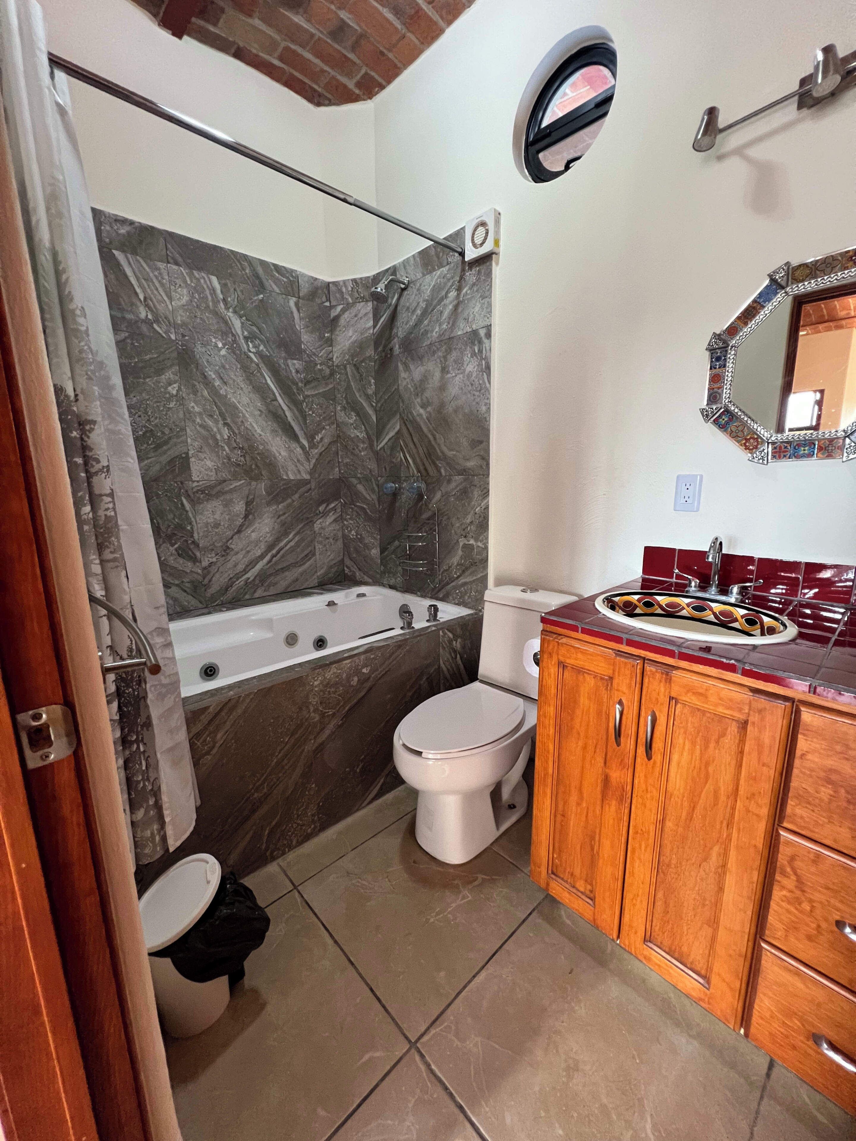 Une salle de bain équipée d’une baignoire, de toilettes et d’un meuble-lavabo avec des tiroirs.