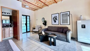 A living room with a sofa, two side tables, a coffee table, a refrigerator, and a kitchen area with cabinets and a sink. - Lirio, Ajijic (Ajijic)