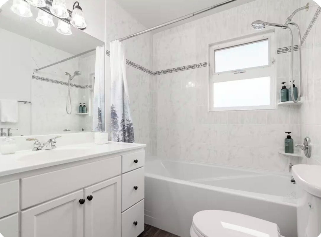 Un baño con tocador blanco, bañera, inodoro y ducha.
