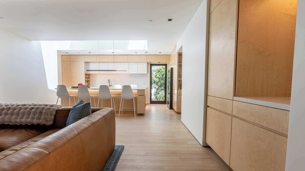 Een modern interieur met een bank, eethoek en keuken.