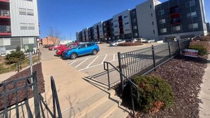 A parking lot with cars, a building with multiple floors, and a sign that says 'PET FRIENDLY'. - Family-Friendly 2BR with Amenities, WiFi & Parking (Des Moines)