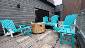 Un espace extérieur aménagé avec quatre fauteuils Adirondack turquoise et une table basse en bois.