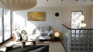 Ein modernes Wohnzimmer mit einer Couch, einem Couchtisch und Kunstwerken an der Wand.