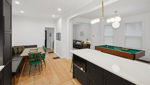 Eine moderne Küche mit Billardtisch, Essbereich und einer gemütlichen Sitzecke.