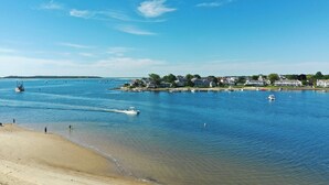 Vistes de la costa amb una platja, aigua tranquil·la i cases al llarg de la riba.