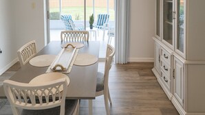 Un espace repas comprenant une table, des chaises et un buffet.