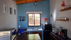A compact kitchen with a wooden ceiling, a window with a view, a sink, a stove, and a refrigerator. - Serene 2-bedroom cabin in charming Mazamitla getaway (Mazamitla)
