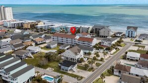 A coastal residential area with a prominent red marker, various single-family homes, and a beachfront. - Cozy Coastal Condo in Murrells Inlet! (Garden City)