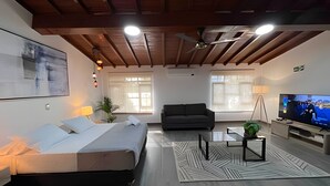 A modern living room with a bed, sofa, TV, and decorative plants. - Apto Palos Altos  (Medellin)