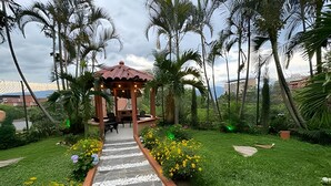 A garden with a gazebo, a stone pathway, and tropical plants. - Apto Palos Altos  (Medellin)
