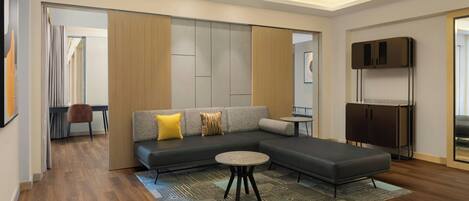 Un salon moderne avec un canapé d’angle, une table basse ronde et un tapis à motifs.