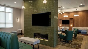 A modern lounge area with a fireplace, seating, and a flat-screen TV. - Residence Inn By Marriott Montgomery Downtown (Montgomery)