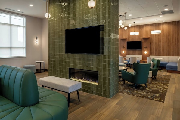 A modern lounge area with a fireplace, seating, and a flat-screen TV. - Residence Inn By Marriott Montgomery Downtown (Montgomery)
