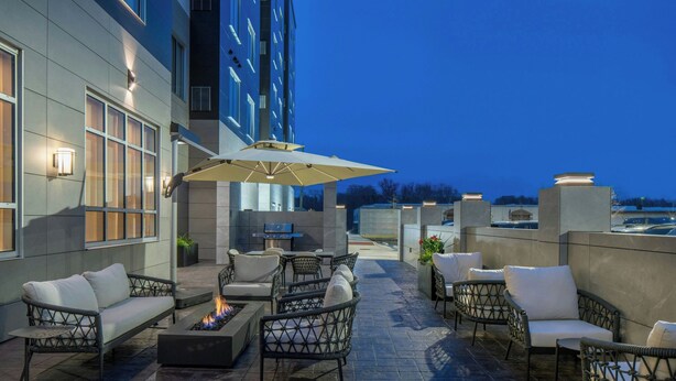 An outdoor patio with wicker furniture, a fire pit, and a TV screen. - Residence Inn By Marriott Montgomery Downtown (Montgomery)