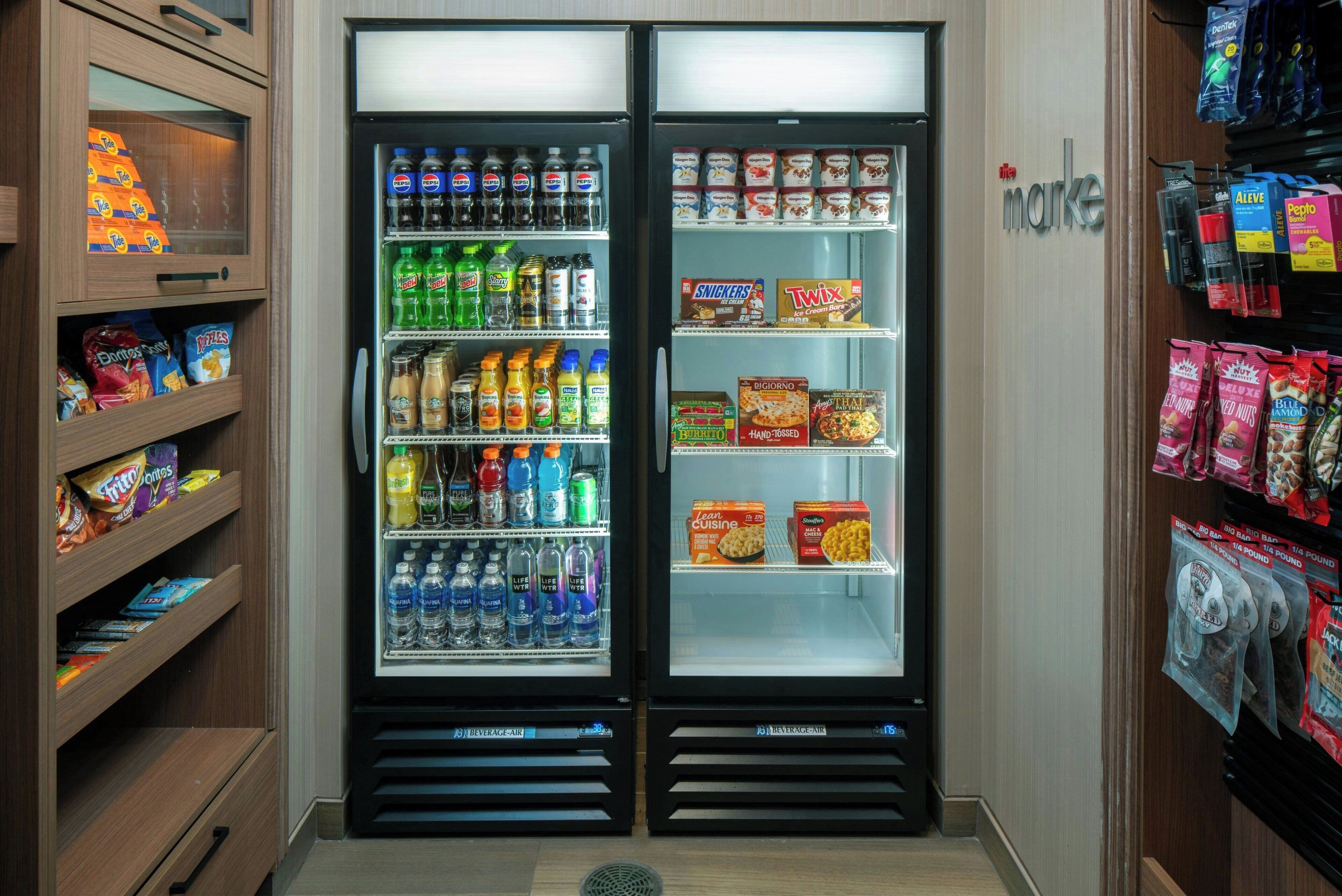 Un miniibar con aperitivos, bebidas y un congelador.