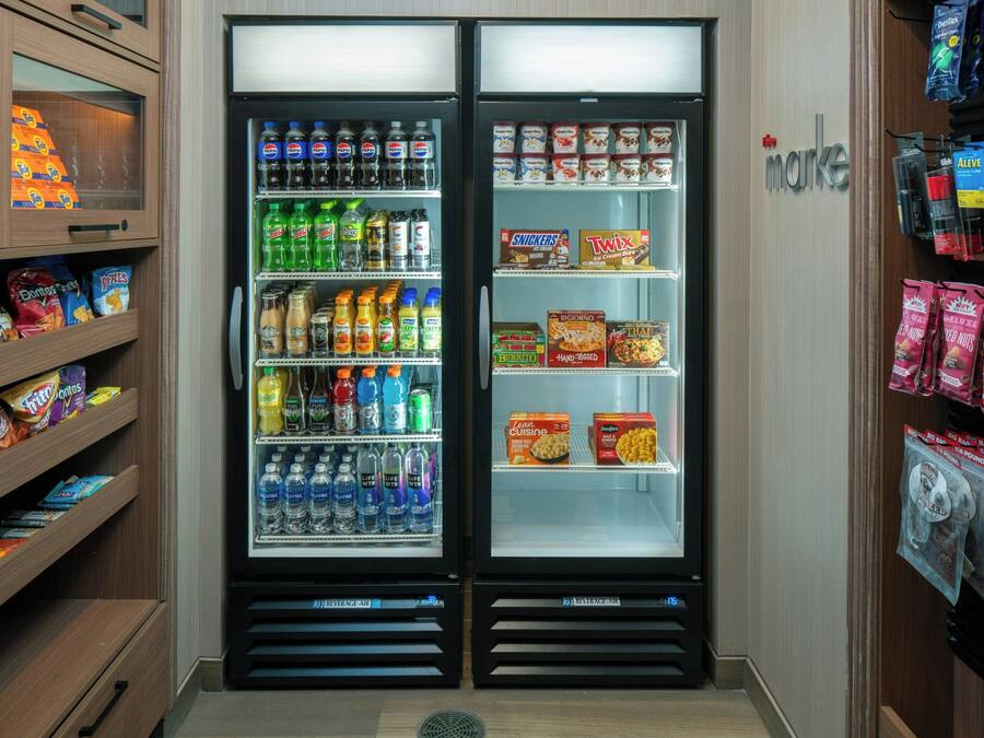 Un miniibar con aperitivos, bebidas y un congelador.