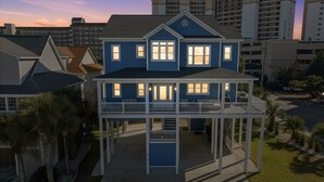 A two-story house with a balcony, a garage, and a driveway. - Surf street + Near the Beach + Pet friendly (North Myrtle Beach)