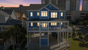 A two-story house with a balcony, a garage, and a driveway. - Surf street + Near the Beach + Pet friendly (North Myrtle Beach)