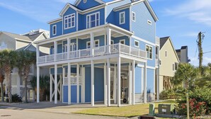 A two-story house with a balcony, white railings, and a garage door. - Surf street + Near the Beach + Pet friendly (North Myrtle Beach)