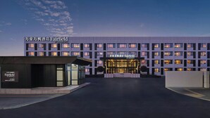 Ένα ξενοδοχείο Marriott Fairfield με μοντέρνα πρόσοψη, πολλά παράθυρα και μια καλά φωτισμένη είσοδο.